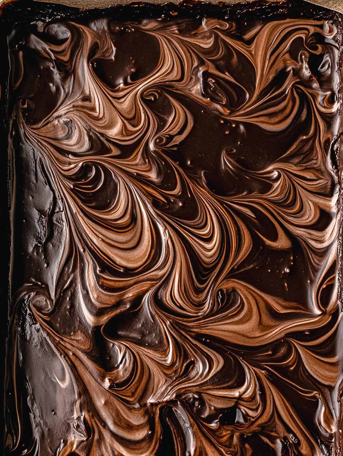 Swirled chocolate gingerbread fudge in a baking tray.