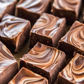 Swirled chocolate gingerbread fudge squares on a marble slab.